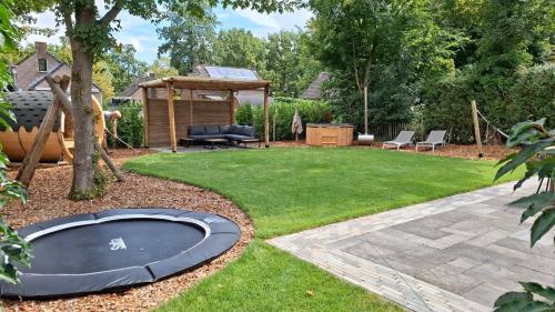 a backyard with a trampoline in the grass at Groene heuvels 101 in Ewijk