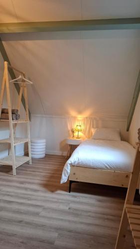 a bedroom with a white bed in a attic at Groene heuvels 101 in Ewijk
