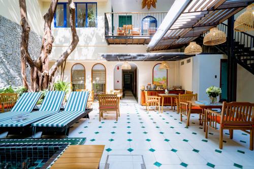 a restaurant with benches and tables and chairs at Sujet Residence Service Da Nang in Da Nang