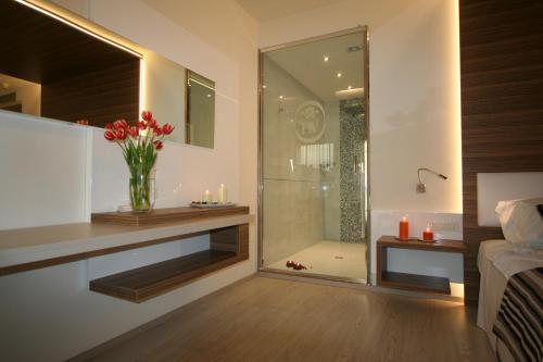 a bathroom with a glass shower with a vase of flowers at Hotel Victoria in Vicenza
