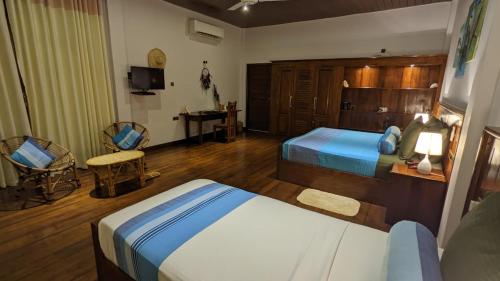 a hotel room with two beds and a desk at Lagoon gate Tangalle Resort in Tangalle