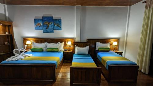 two beds in a room with two beds sidx sidx sidx at Lagoon gate Tangalle Resort in Tangalle