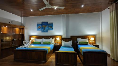 a bedroom with two beds and a ceiling at Lagoon gate Tangalle Resort in Tangalle