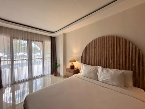 a bedroom with a large bed and a large window at Segreto Boutique Resort in Gili Trawangan