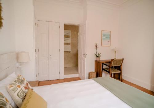 a bedroom with a bed and a desk and a chair at Porto Surf Lodge in Porto