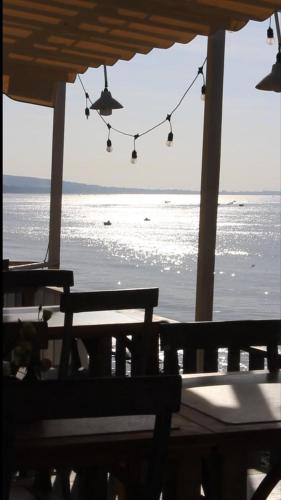 a porch with a view of the ocean and a bench at Sabina Boutique Hotel & Villa Mui Ne in Mui Ne