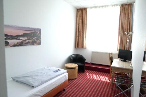 a bedroom with a bed and a desk with a computer at B&K Hotels in Vlotho