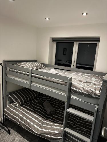 a bedroom with two bunk beds and a mirror at The Scouse Suite in Liverpool