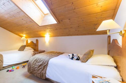 a bedroom with two beds and a skylight at Résidence Pierre & Vacances Premium Arc 1950 Le Village in Arc 1950
