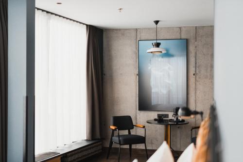 a room with a table and chairs and a large window at Exeter Hotel in Reykjavík