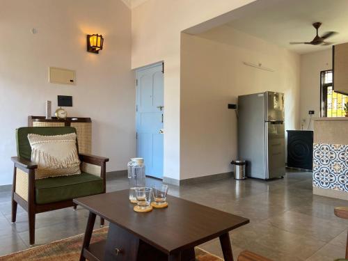 a living room with a table and a refrigerator at Aesthetic Apartment in NorthGoa in Siolim