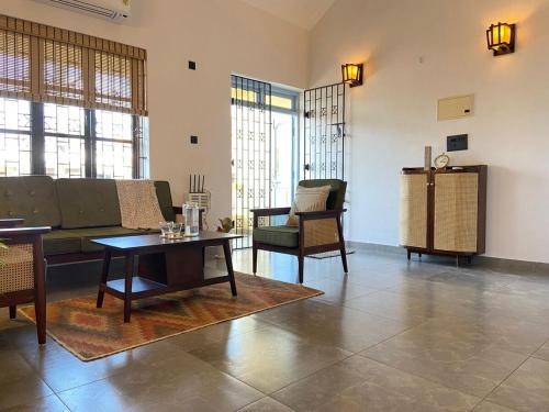 a living room with a couch and a table and chairs at Aesthetic Apartment in NorthGoa in Siolim