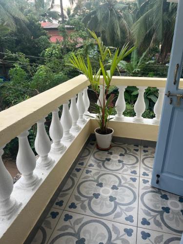 a staircase with white vases and plants on a balcony at Aesthetic Apartment in NorthGoa in Siolim