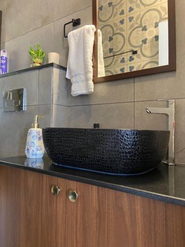 a bathroom with a black sink on a counter at Aesthetic Apartment in NorthGoa in Siolim
