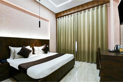 a bedroom with a large bed and a window at FabHotel Prime The Rivlet - MG Road & Sikanderpur Metro in Gurgaon