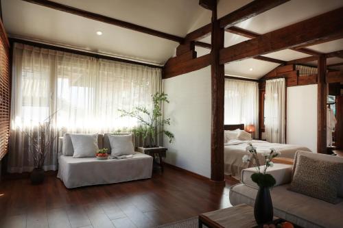 a bedroom with two beds and a living room with a couch at Lijiang Sadhu Inn in Lijiang