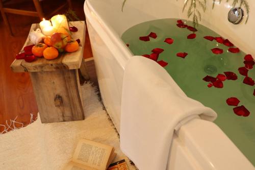 a bathroom with a toilet with flowers in the water at Lijiang Sadhu Inn in Lijiang