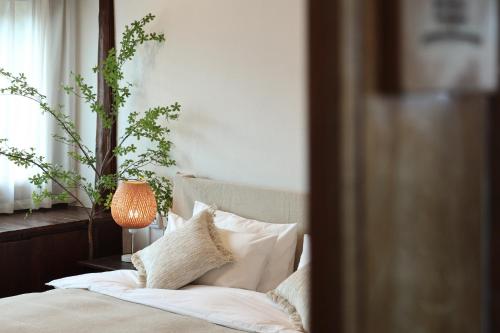a bed with white pillows and a table with a lamp at Lijiang Sadhu Inn in Lijiang
