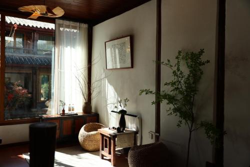 a living room with a table and a window at Lijiang Sadhu Inn in Lijiang