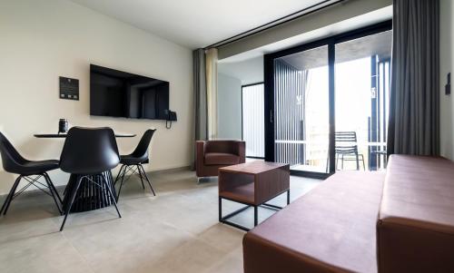 a living room with a couch and a table with chairs at Onyx Hotel in St Julian's