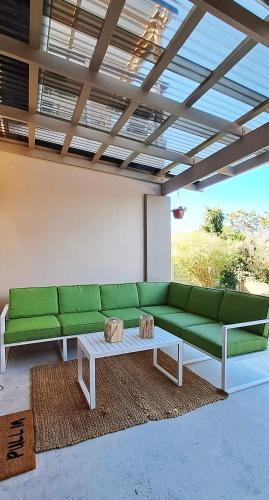 sala de estar con sofá verde y mesa de centro en Zamalek Self-catering, en Plettenberg Bay