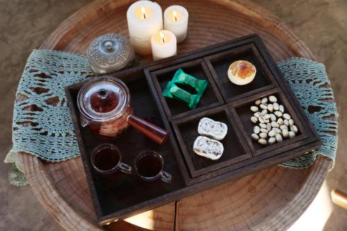 a table with a tray of food and candles at Lijiang Sadhu Inn in Lijiang