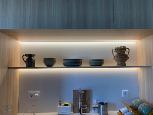 a shelf with bowls and plates on it at Póvoa 3 suites in Póvoa de Varzim