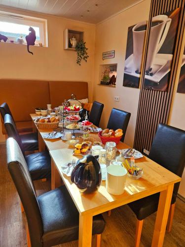 a table with food on it with chairs around it at Kleines Landhaus Wendel in Kapellen-Drusweiler
