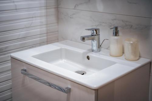 a white bathroom sink with two candles on it at TRINAVIS Boutique Apartments, OWN PRIVATE PARKING, City Center, Entire Apartment in Veliko Tŭrnovo