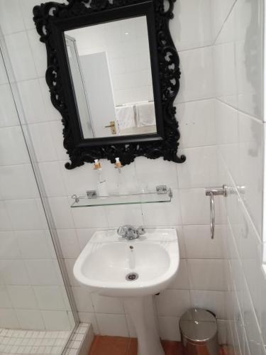 a bathroom with a sink and a mirror on the wall at Q on First B&B in Johannesburg