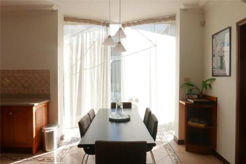 a dining room with a table and chairs and a large window at Fantastic Family Home with Pool at Concord in Sydney
