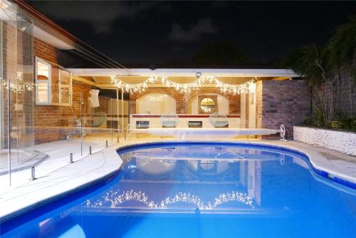 a swimming pool in a backyard at night at Fantastic Family Home with Pool at Concord in Sydney