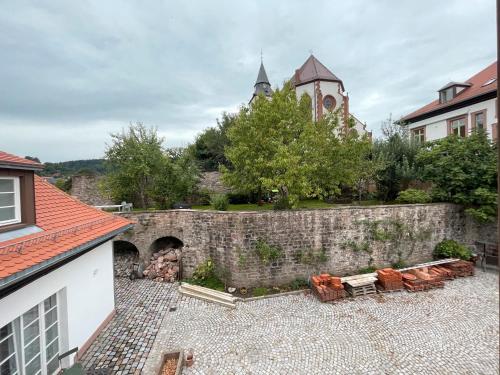 a stone wall next to a building and a church at Altes Kutschhaus in Gernsbach