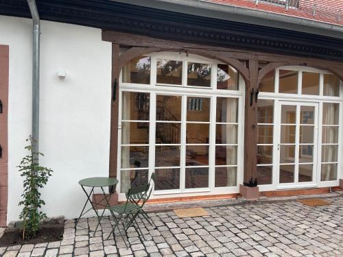 a table and a chair in front of a building at Altes Kutschhaus in Gernsbach