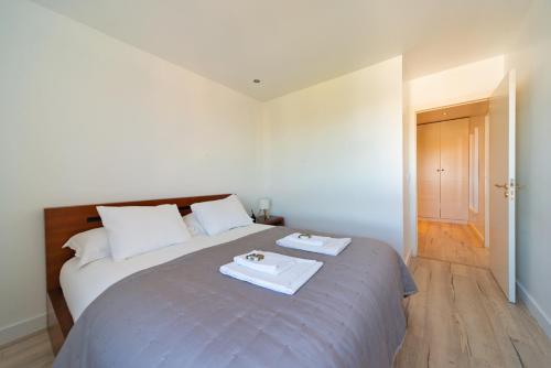 a bedroom with a bed with two plates on it at Modern 2 Bedroom Apartment with Balcony in Cascais in Cascais
