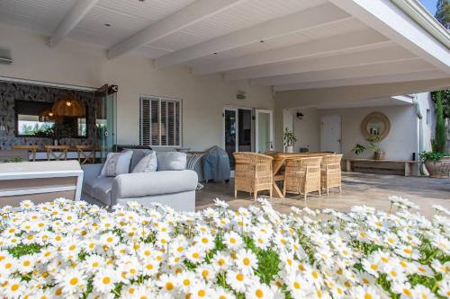 a patio with a couch and chairs and flowers at 26 on Bree in McGregor