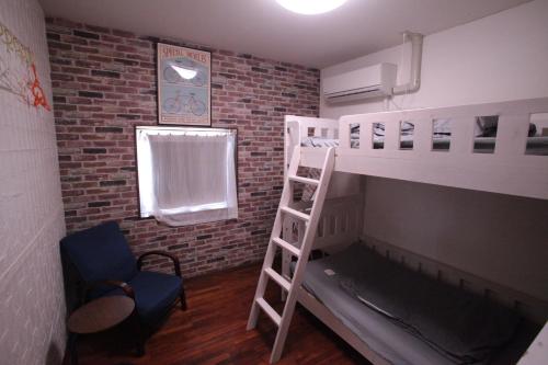 a room with two bunk beds and a ladder at M&Unity in Okinawa City