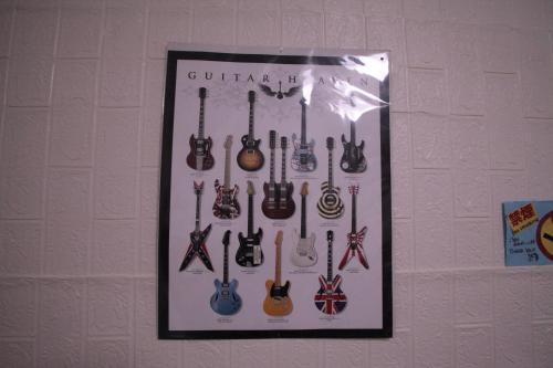 a picture of a bunch of guitars hanging on a wall at M&Unity in Okinawa City