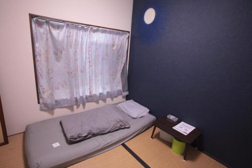 a small bed in a room with a window at M&Unity in Okinawa City