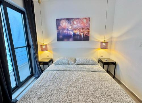 a bedroom with a large bed with two night stands at Adira Bay Hideaway - Fast WiFi and Home Office in Is-Sellum