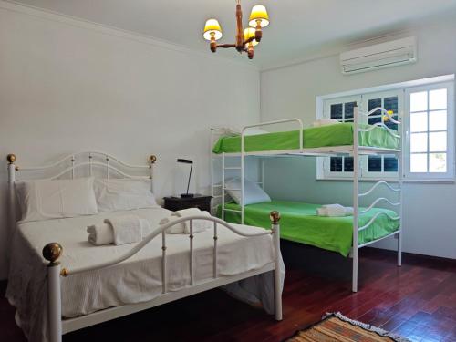 a bedroom with two bunk beds and a window at Solar das Mimosas 2 casas in Sintra
