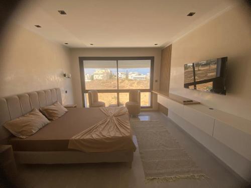 una camera da letto con un letto e una TV a schermo piatto di Casa del Papel a Akouda