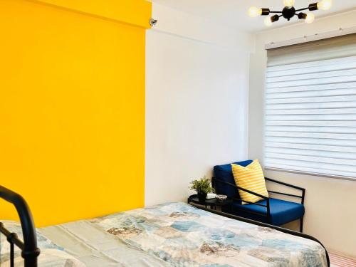 a bedroom with a bed and a blue chair at Studio By The Sea in Dumaguete