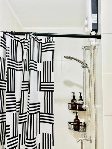 a black and white shower curtain in a bathroom at Studio By The Sea in Dumaguete