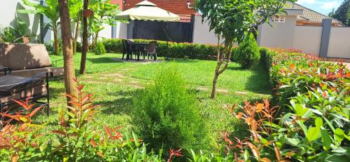 a garden with a bench and a table and trees at Oreville Apartments in Goma