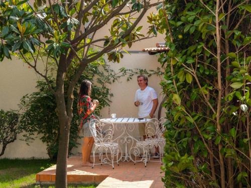 two women standing around a table in a garden at Porto Surf Lodge in Porto