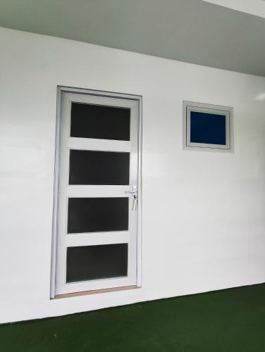 a white wall with a window in a room at Anilao Mabini Sea House Diveshop and Resort in Mabini