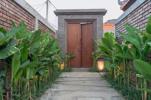 a wooden door in a brick building with plants at Serenia Villas Amed in Amed