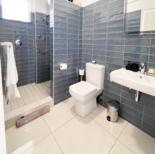 a bathroom with a toilet and a shower and a sink at Comfort Zone Suites - Hidas 2 in Windhoek