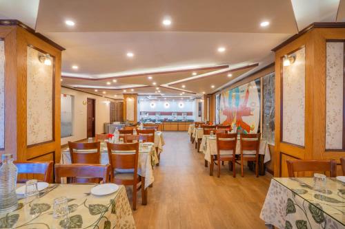 a dining room with tables and chairs in a restaurant at Yashshree Jai Hotel & Banquet in Darjeeling